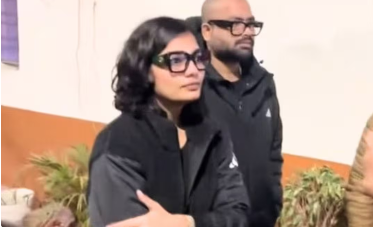 लखनऊ के हजरतगंज थाने के बाहर पति के साथ खड़ी लोक गायिका नेहा सिंह राठौर, FIR मामले के सिलसिले में पहुंची हुईं।